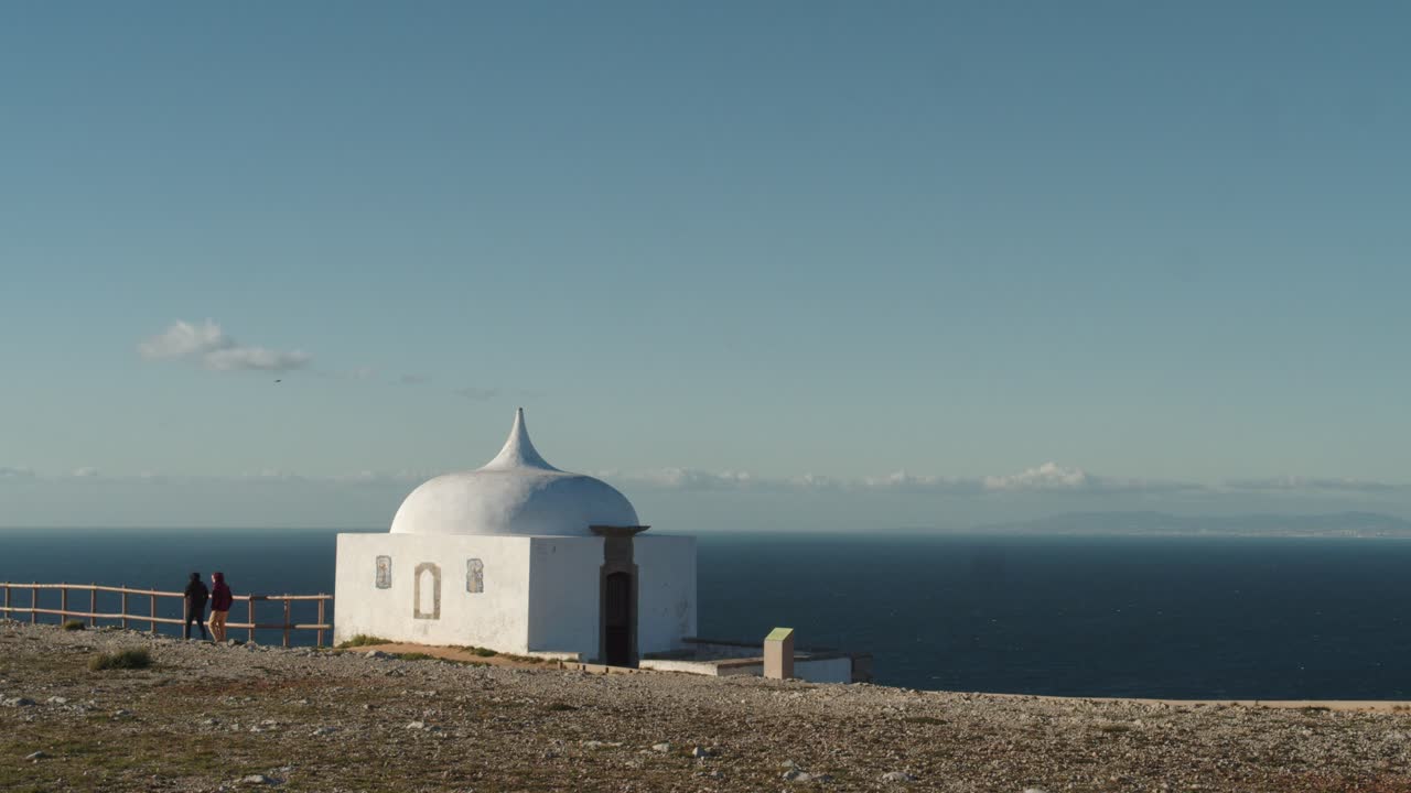 los turistas pasan por una pequeña ermita en cabo espiechel