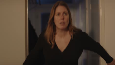 frightened woman looking at something off screen, she gets scared and flees her home