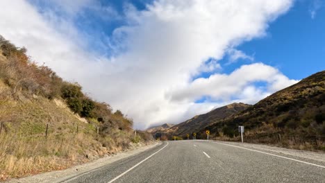 a 30-second drive through wanaka's winding roads, showcasing stunning mountain views under a bright blue sky