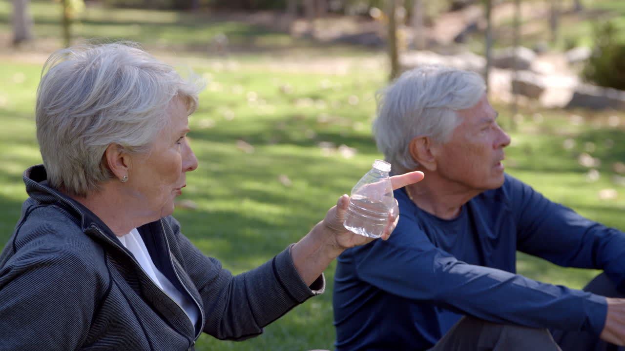 노인 부부가 공원에서 함께 운동 한 후 휴식을 취하고 있습니다.