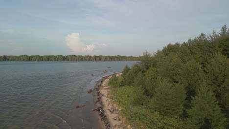 aerial drone view during summer gerigat fishing village,kabong with, facing open blue sea, white sandy beach,green coconut, palm trees,and river,sarawak,borneo