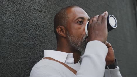 african american man drinking a coffee and using his phone