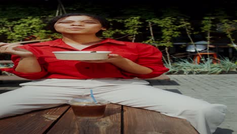 mujer comiendo ramen al aire libre