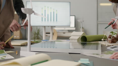 close up of an unrecognizable team discussing about renewable energy project in the office 1