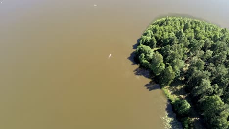 Diminuto-Bote-A-Toda-Velocidad-A-Través-Del-Tranquilo-Lago-De-Polonia,-Vista-Aérea-De-Drones