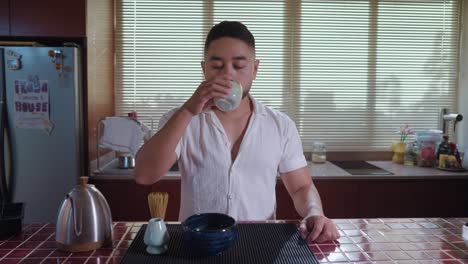 man enjoying matcha tea ceremony in kitchen