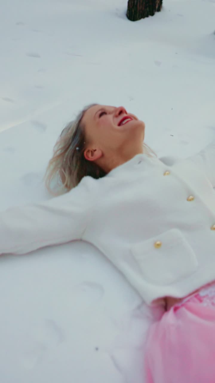 Joyful Woman Laughing While Lying in Fresh Winter Snow