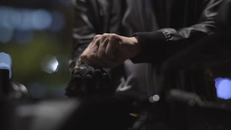 slow mo, motorcycle rider wearing and testing his gloves
