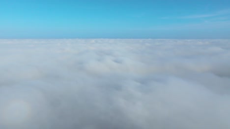 bed of white fluffy clouds in blue clear horizon