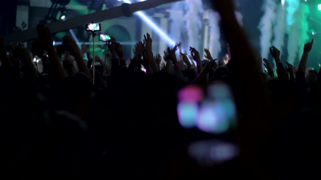 Fan di musica entusiasti che ballano con le mani alzate