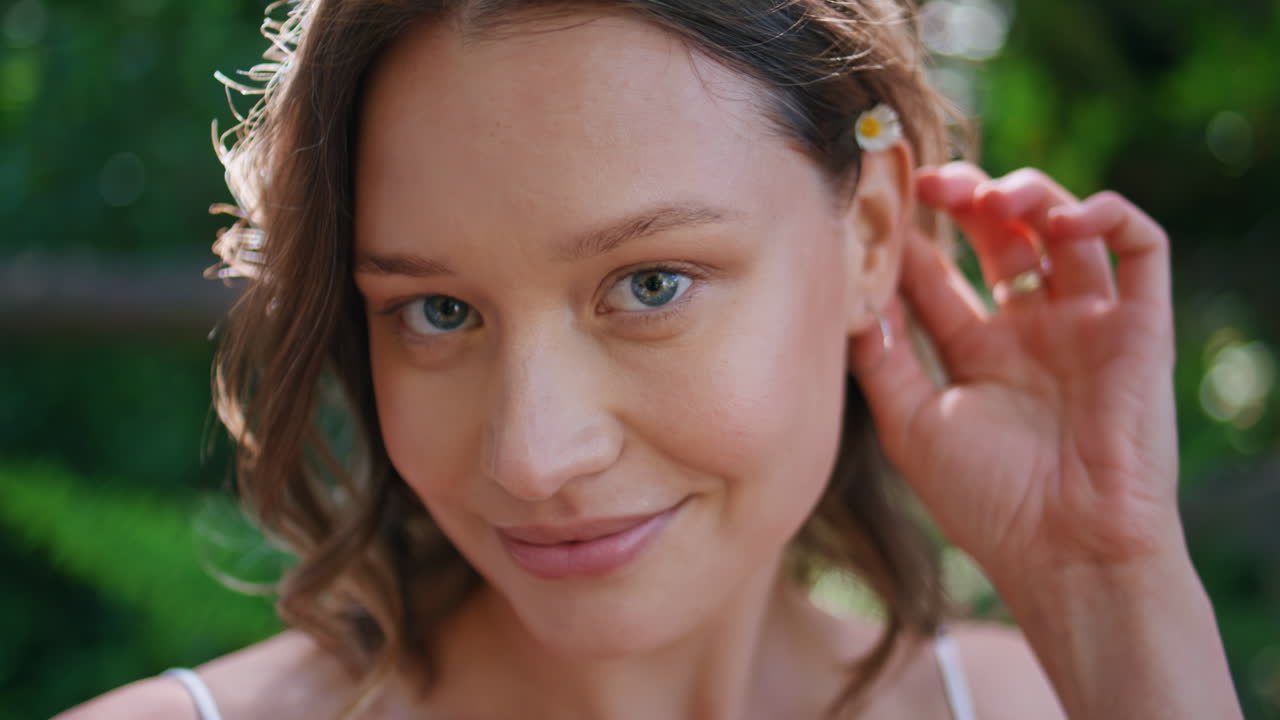Girl posing greenery park closeup. Carefree woman putting flower hair portrait