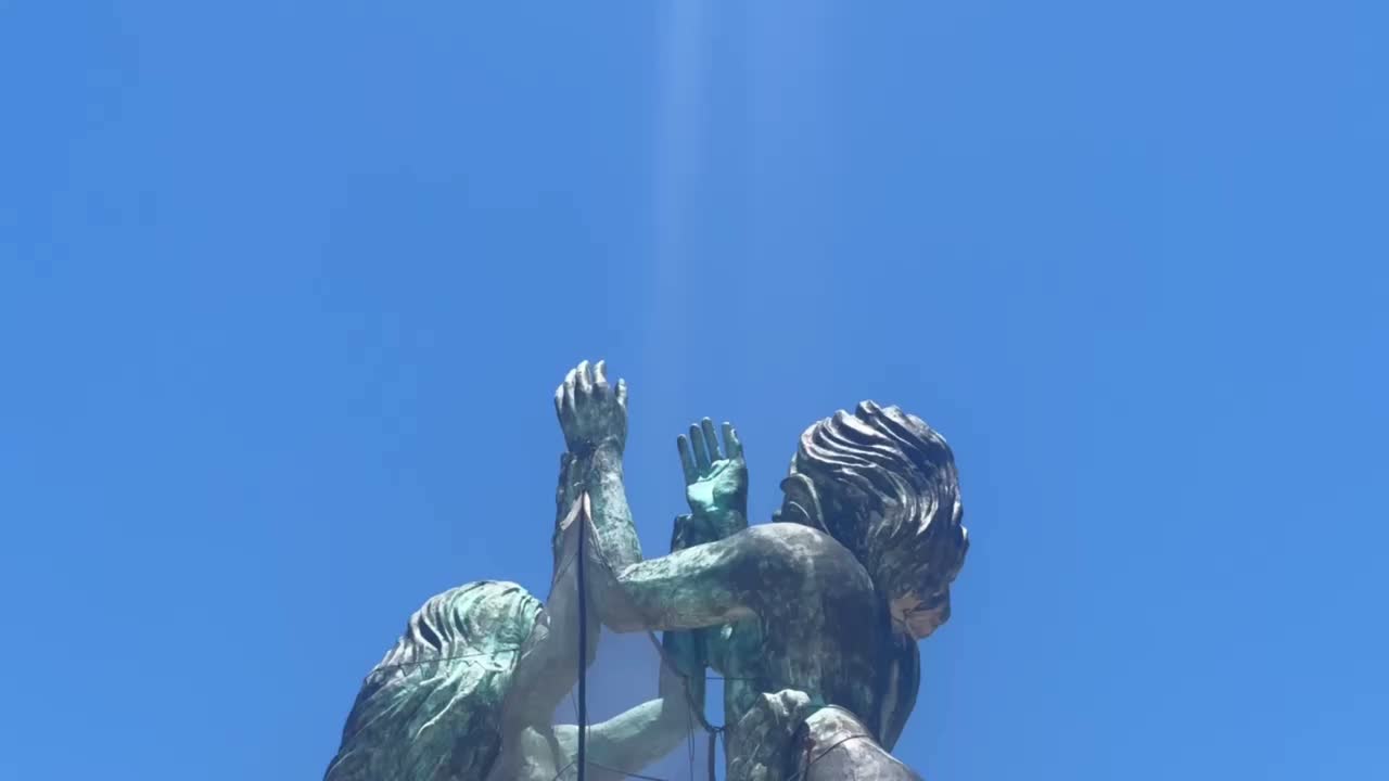 Handheld close-up booming down shot of the mermaid figures at the top of the Portal Maya sculpture in Playa del Carmen, Mexico. 4K