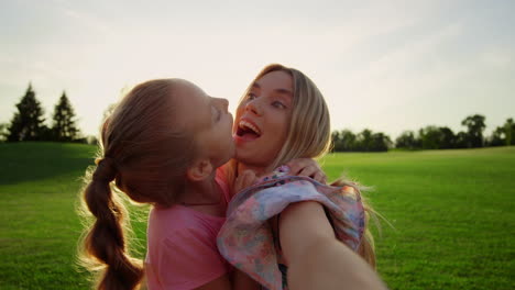 family fooling in city park. mother and daughter posing to camera outdoor.