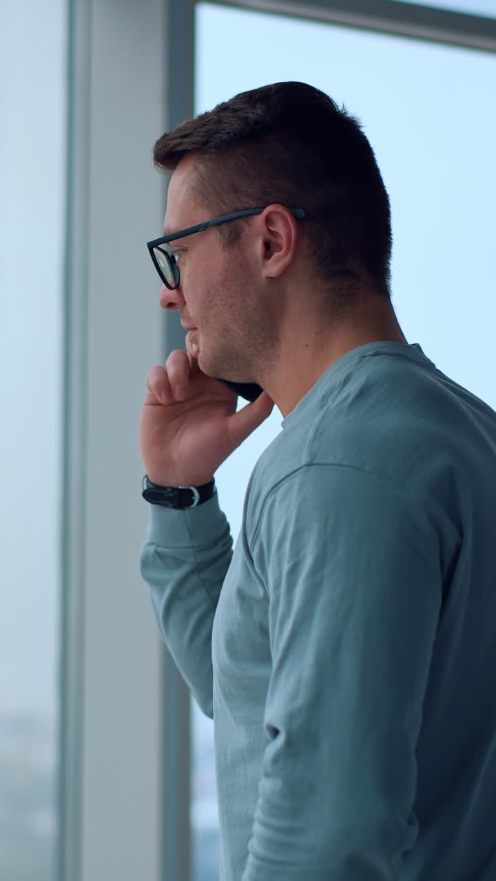 Man Talking on Phone by Window