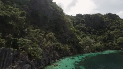 toma de drones fpv de la jungla del acantilado junto a la bahía de agua turquesa en coron, paisaje impresionante