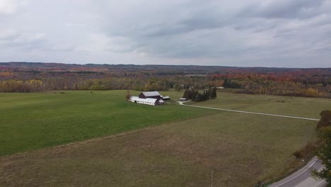 aerial flying towards farmland on cloudy autumn day, caledon, canada