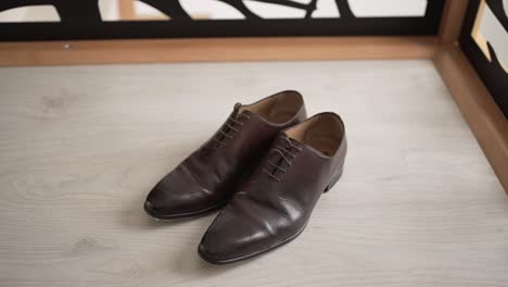 elegant brown leather dress shoes placed neatly on light wooden floor for wedding