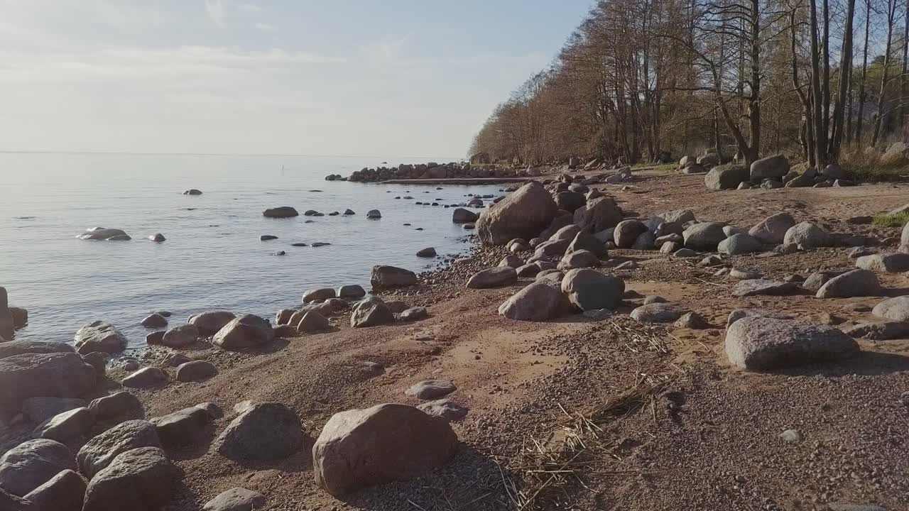Steinete strandlinje med mange kampesteiner og blått hav, nordisk natur.