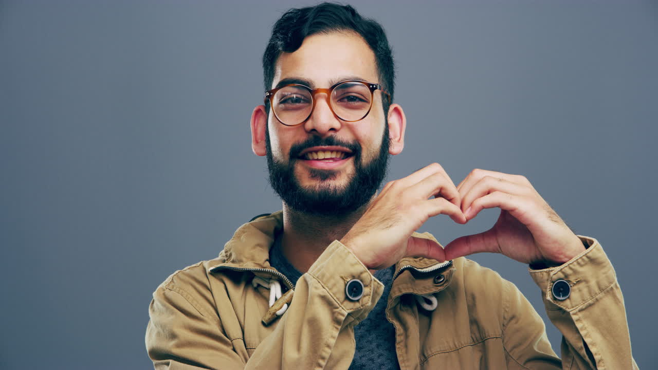 hombre sonriente haciendo forma de corazón con las manos