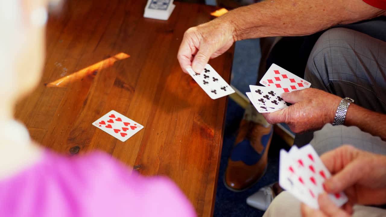 sección media de personas mayores jugando a las cartas en el hogar de ancianos 4k