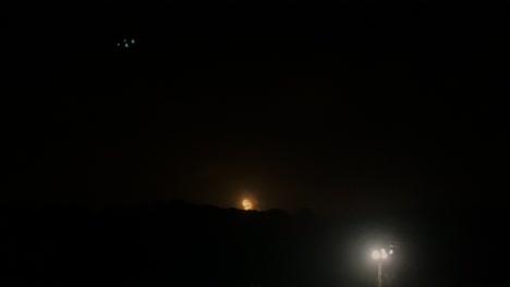 noche gran luna llena y brillante se eleva desde arriba de la colina hacia el cielo