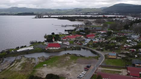 Small-living-Maori-village-with-historic-buildings-and-War-Memorial---Aerial-view-of-Ohinemutu-Rotorua-city-suburb-on-lakeshore