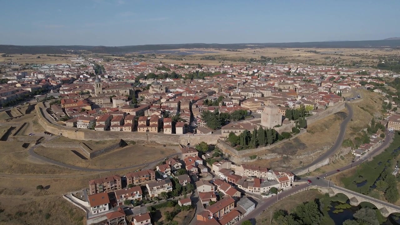 Ripresa aerea panoramica di Ciudad Rodrigo che rivela l'intera città fortificata, la cattedrale e i paesaggi circostanti nella provincia di Salamanca, Spagna. Drone sopra il fiume che si muove in direzione della fortificazione