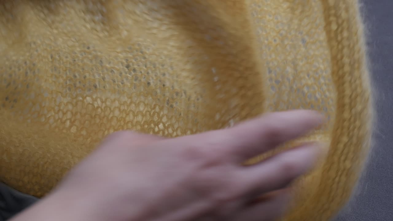 Yellow knitting project on needles, capturing calm craftsmanship