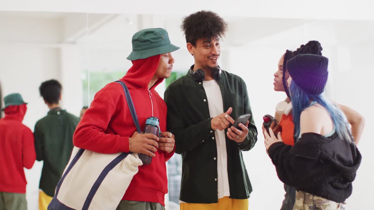 행복한 다양한 남녀 댄서들이 댄스 스튜디오에서 스마트폰을 사용하고 이야기하고, 슬로우 모션