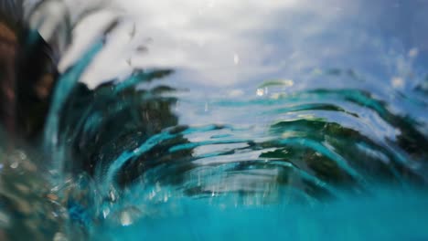 footage of a bubble tube underwater in a swimming pool creating ripples and distorted images