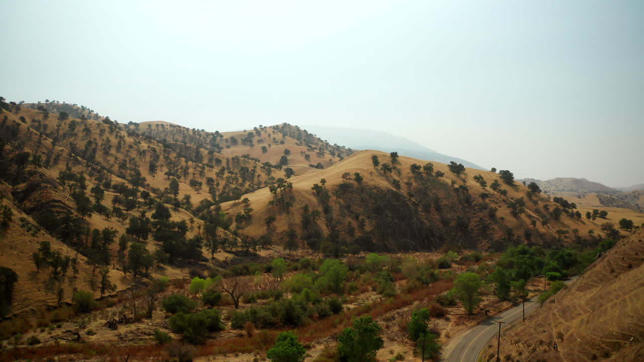 subindo acima de uma estrada e leito de rio seco durante um ano de seca e alerta de incêndio florestal - vista aérea