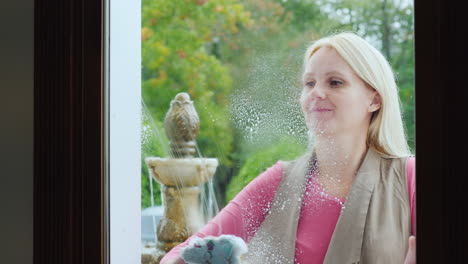 a woman rubs a window in a cafe or a small store view from inside the room