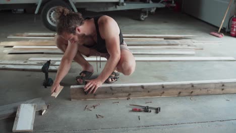 woodworker uses f-clamps to join wood planks for gluing and drilling