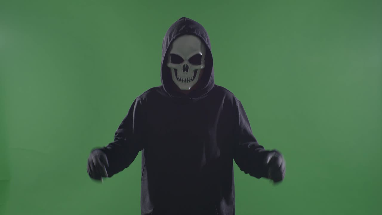 녹색 스크린 배경에 칼을 들고 웃는 할로윈 마스크를 입은 후드 스웨트 셔츠를 입은 미치광이 남자