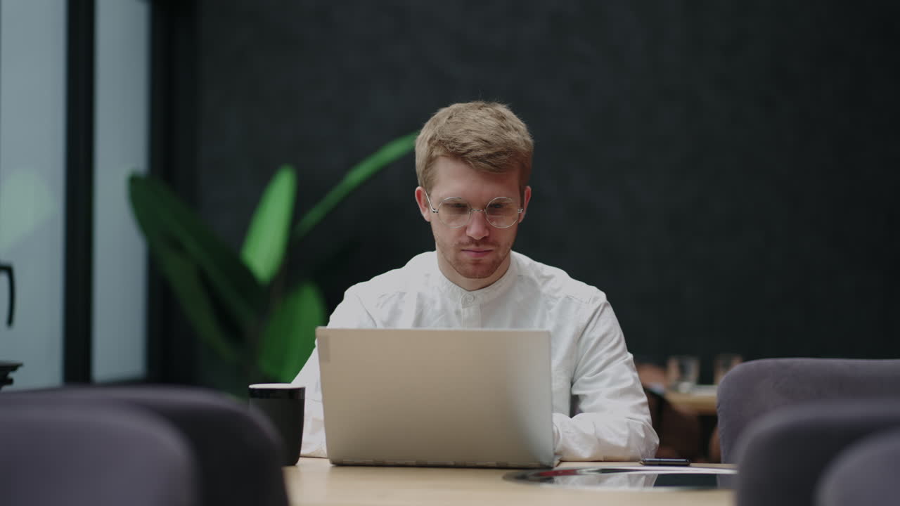 Portrait of young man sitting at his desk in the office