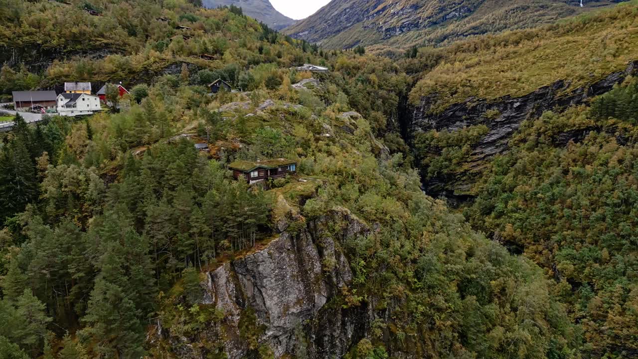 Aerial over the hills with typical housing and falls of Gieranger, Norway