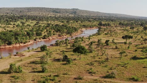 Aerial-drone-shot-of-Maasai-Mara-River-Landscape-Scenery-in-Masai-Mara-National-Reserve-in-Kenya,-Beautiful-Africa-From-Above-with-Trees-Greenery-and-Lush-Green