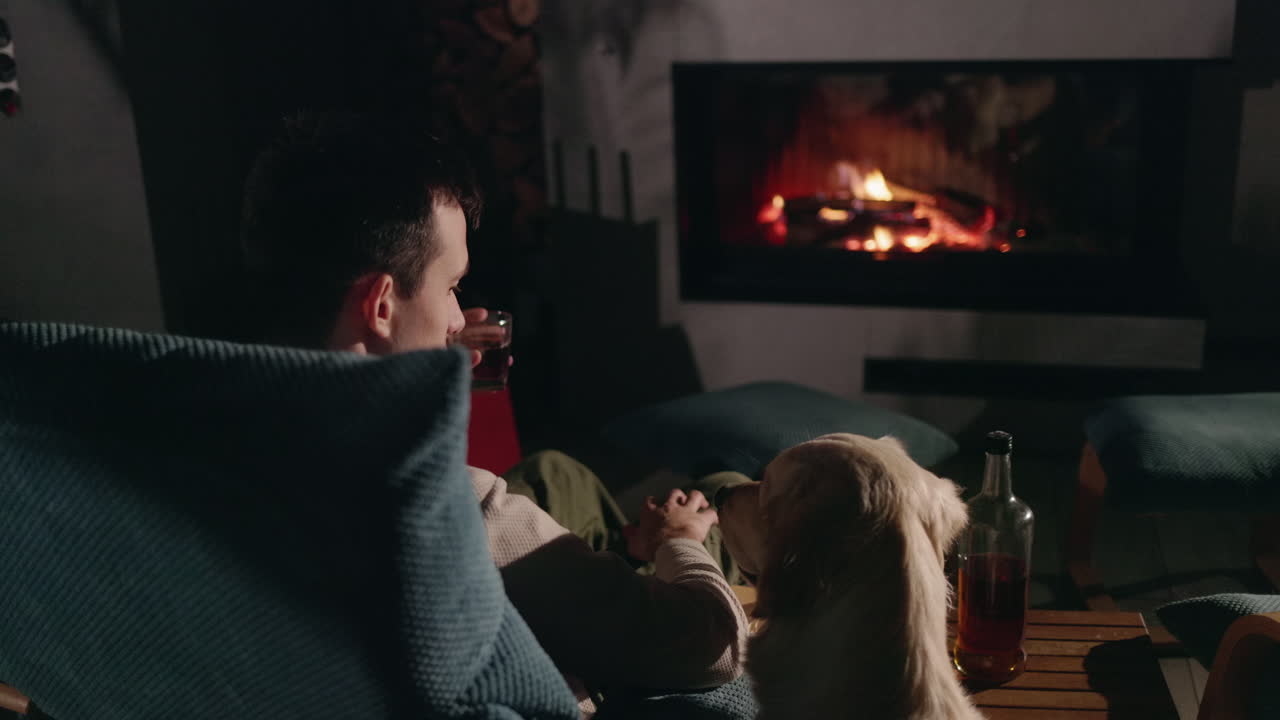 hombre y perro disfrutando de una noche junto a la chimenea