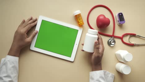 el médico de bata blanca está usando una tableta digital, de arriba hacia abajo