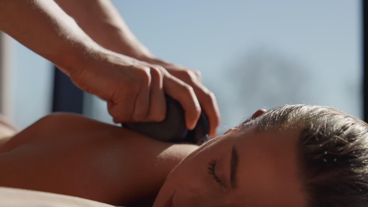 Nærbillede af kvinde der får hot stone massage på et spa