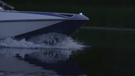 speedy motor boat floating on river in evening. boat bow cutting water