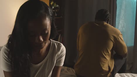 pareja con problemas de relación en casa por la noche ambos mirando teléfonos móviles en el dormitorio 1