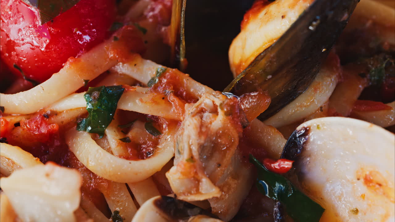 Close up of pasta with seafood and tomato sauce on a plate at a restaurant