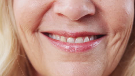 Close-Up-Of-Mouth-As-Mature-Woman-Smiles-At-Camera-In-Studio