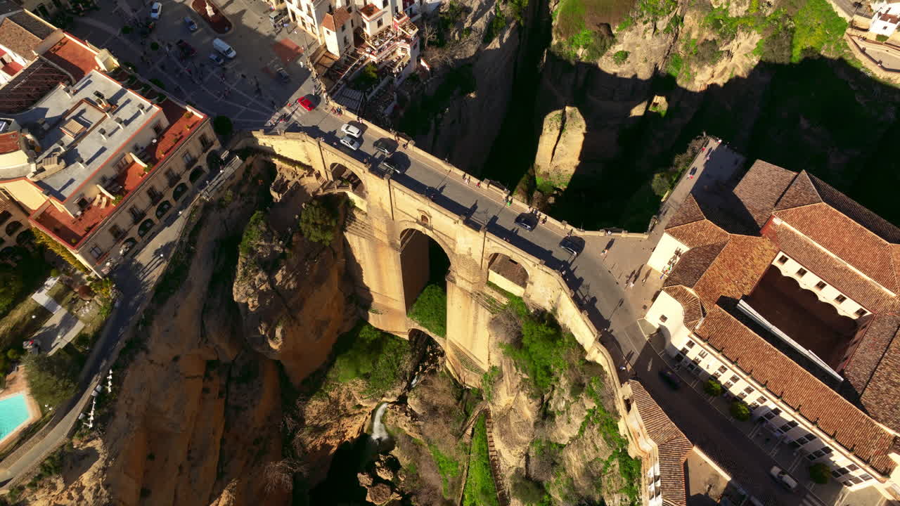 Ascending aerial shot of Ronda City in Spain, Europe. Arch bridge, homes, streets are located on the cliff. Mountains are visible in the background. High quality 4k prores footage.
