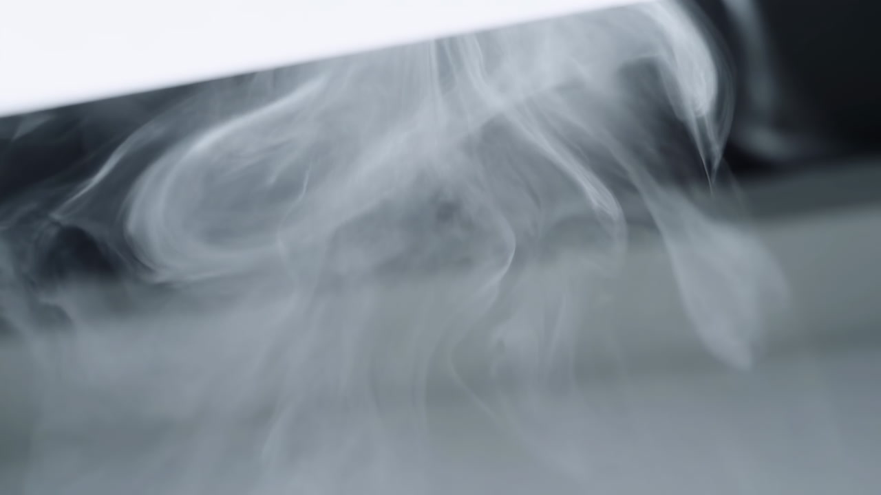 Soft Gray Smoke Rising Over Surface, Curling Wisps And Diffused Studio Light Creating Serene Abstract Motion