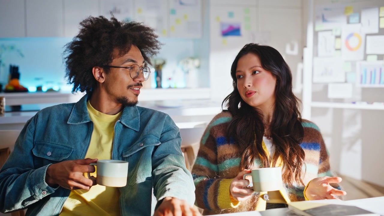 Coworkers chatting coffee break home office. Multiethnic partners holding mugs.