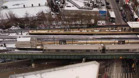 a aerial, profile view a subway train stopped at a station on a snowy day