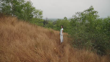 girl tourist with umbrella at rural mountain in bushes