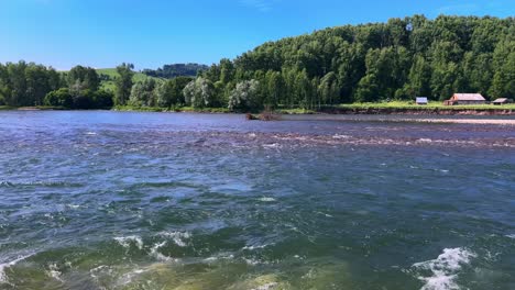 a tranquil river scene captured: gentle waves and lush greenery under a bright blue sky in a scenic natural landscape